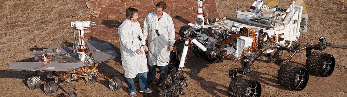 Des ingénieurs entourés de rovers conçus pour Mars.