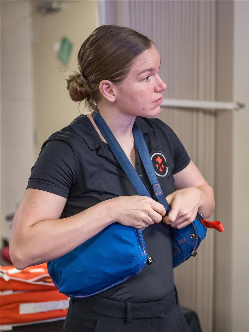 Jenni wears two waist pouches fastened to a strap around her neck.