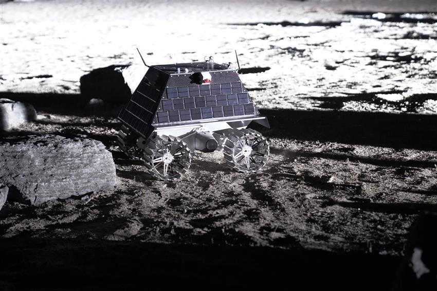 Picture of a rover exploring a Moon-like surface.