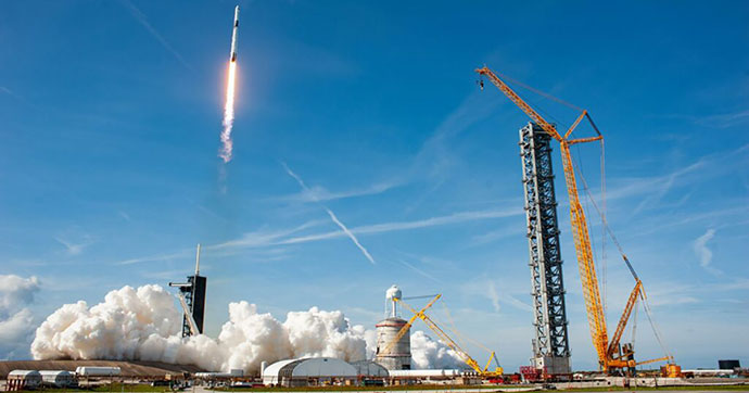 Une fusée Falcon 9 vient tout juste de décoller d'un pas de tir, par beau temps.