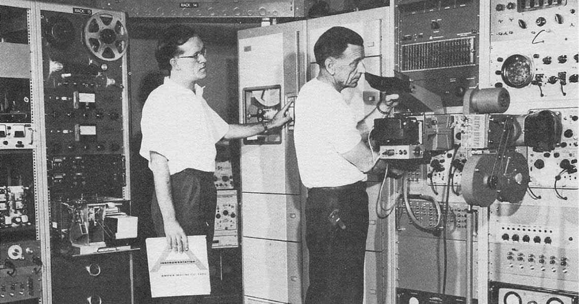 Two Canadian engineers check equipment used to process Alouette-I data.