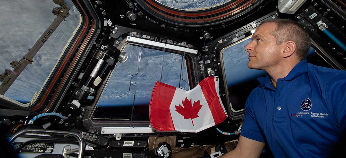 David Saint-Jacques regarde par une fenêtre de la coupole de la Station spatiale internationale
