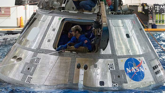 Un astronaute en uniforme dans une capsule spatiale sur l'eau