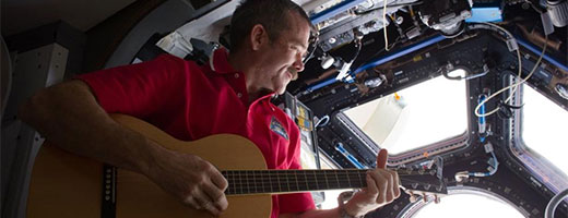 Chris Hadfield joue de la guitare dans la coupole d'observation de la Station spatiale