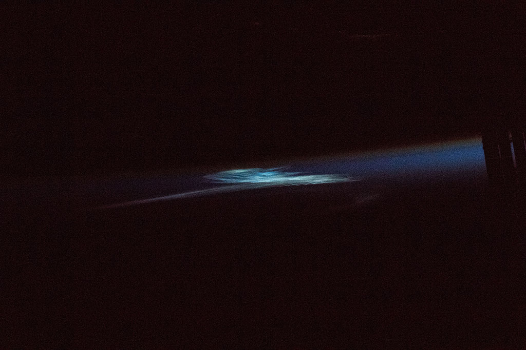 Les nuages noctulescents sont les nuages les plus hauts dans l'atmosphère terrestre. Ils sont composés de cristaux de glace et sont visibles seulement lorsqu'ils sont illuminés par les rayons du soleil depuis le dessous de l'horizon alors que les couches les plus basses de l'atmosphère sont dans l'ombre de la Terre. Cette photo a été prise par David Saint-Jacques depuis la Station spatiale internationale. (Source : Agence spatiale canadienne/NASA.)