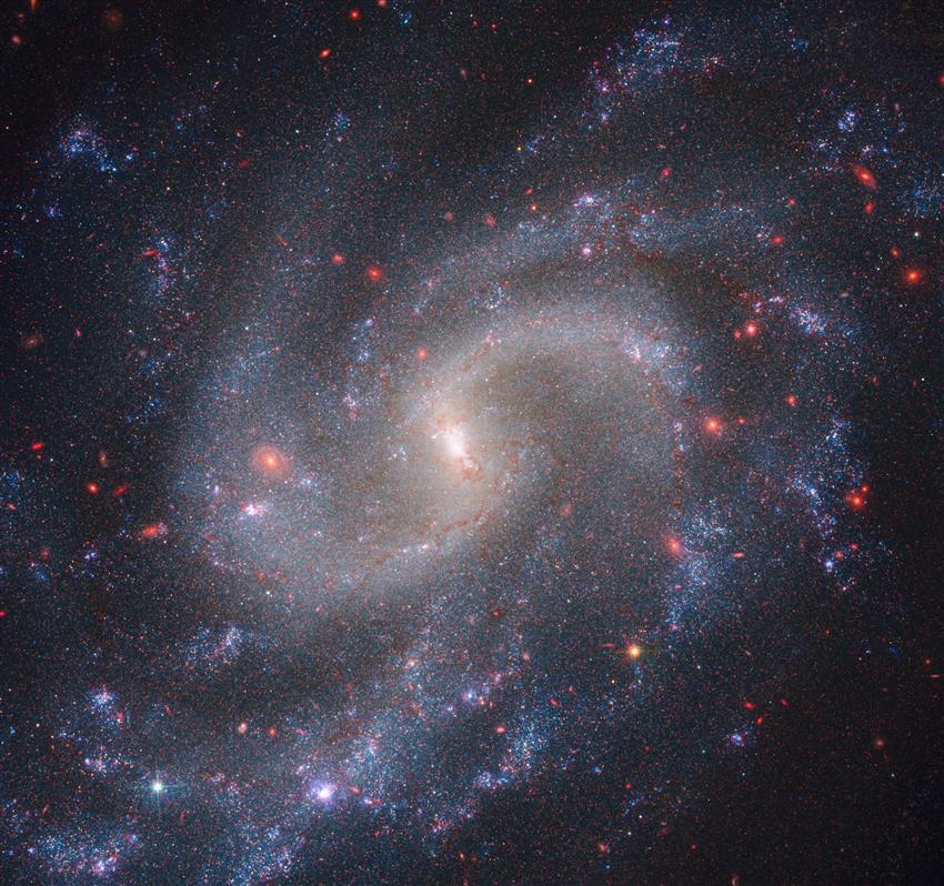 Webb and Hubble composite image of a galaxy with bright white core and blue spiral arms.