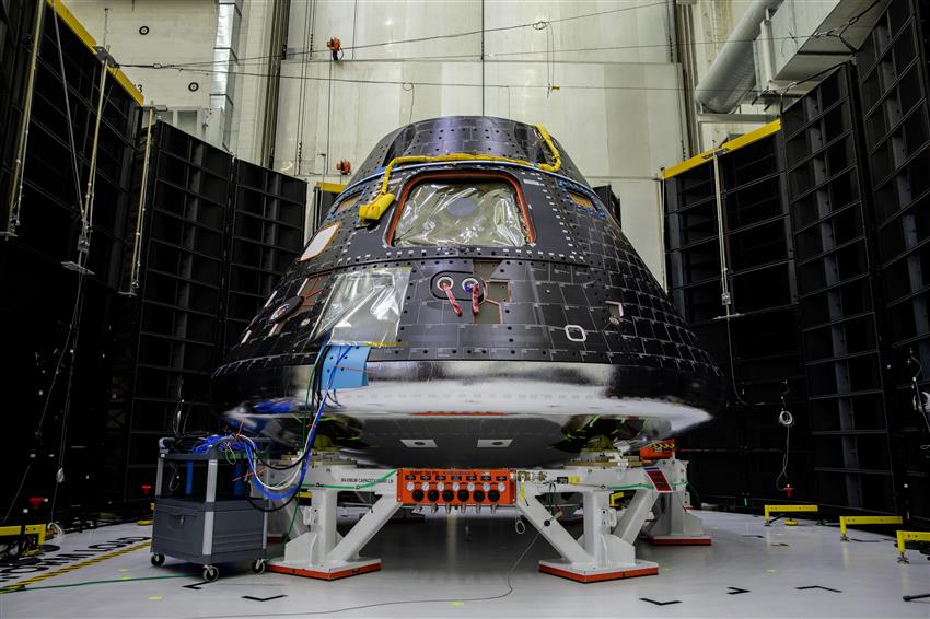 The tear-shaped Orion crew module has black paneling on the outside and a silver heat shield on the bottom.