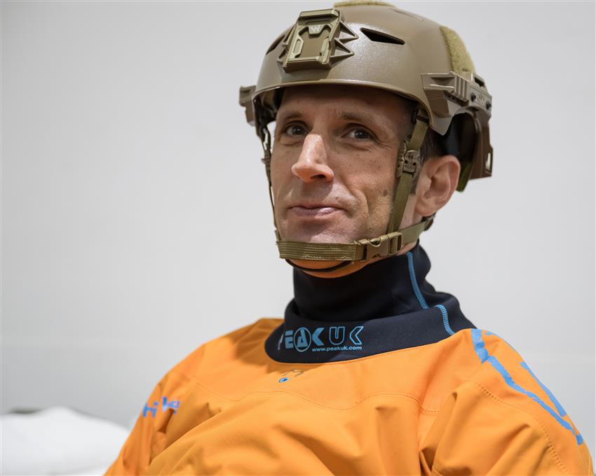 Gros plan de Joshua portant un casque et une combinaison imperméable. 