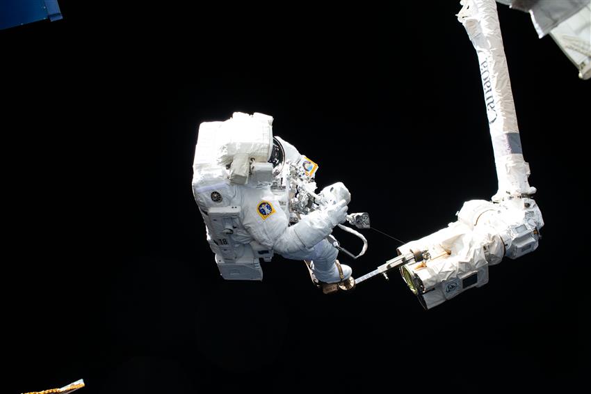 L'astronaute Luca Parmitano a les pieds bien fixés au bras robotisé Canadarm2 lors d'une sortie dans l'espace