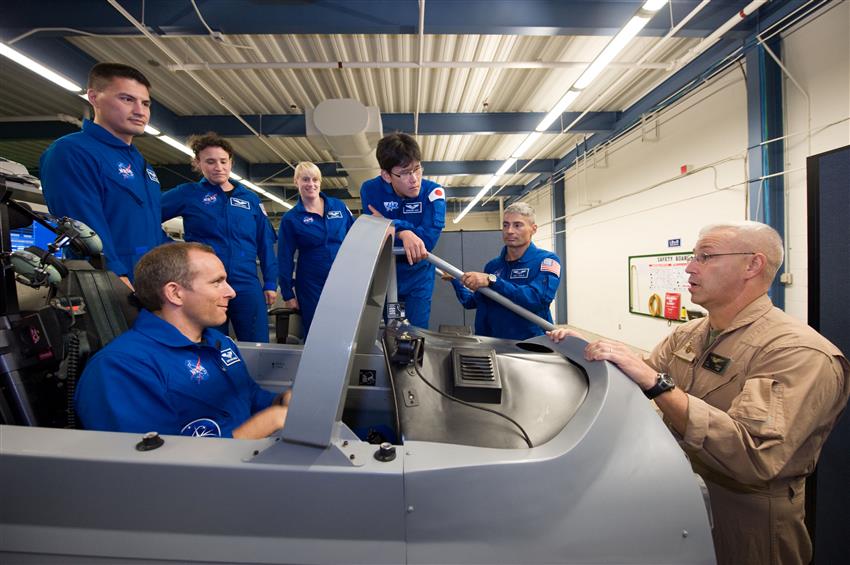 David Saint-Jacques, assis dans le cockpit d'un simulateur