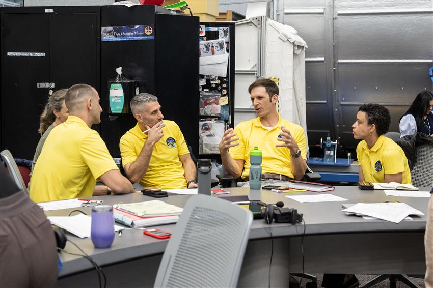 Sergueï, Luke, Joshua et Jessica se parlent autour d'une table.