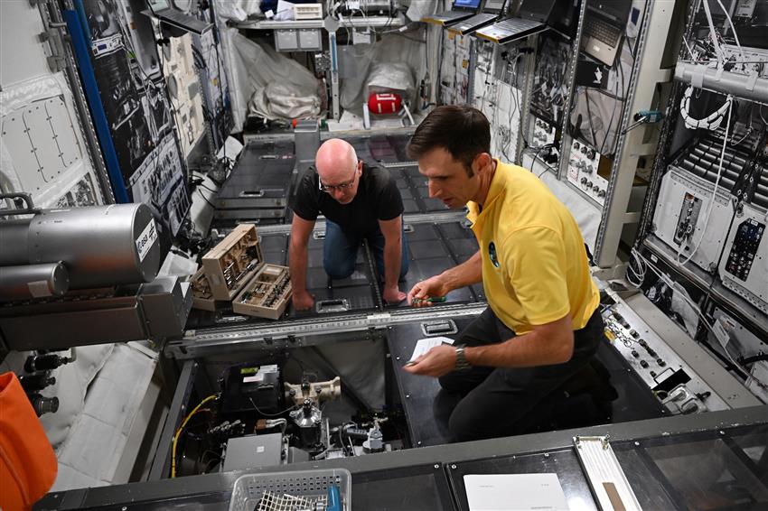 Joshua and a trainer look at machinery in a simulator. 