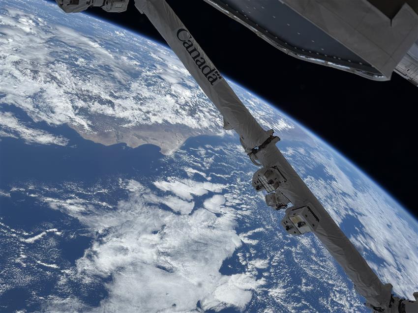Canadarm2 above Earth's horizon, as seen from the International Space Station.
