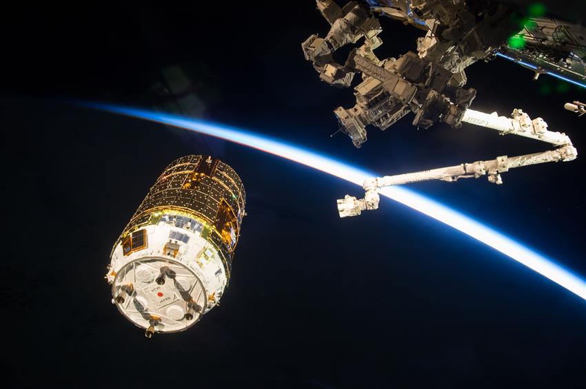 Canadarm2, the International Space Station's robotic arm, grapples an unpiloted resupply ship