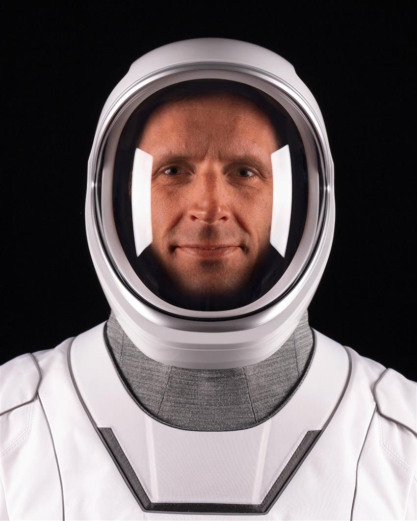 Gros plan de Joshua portant une combinaison spatiale et un casque avec la visière fermée. 