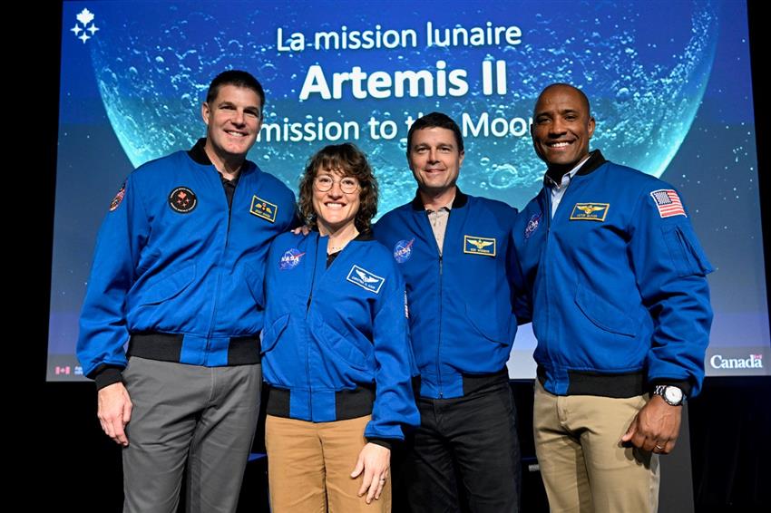 Quatre astronautes debout sur scène.