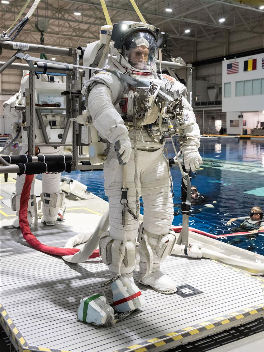 Joshua dans une combinaison spatiale sur le bord d'une très grande piscine.