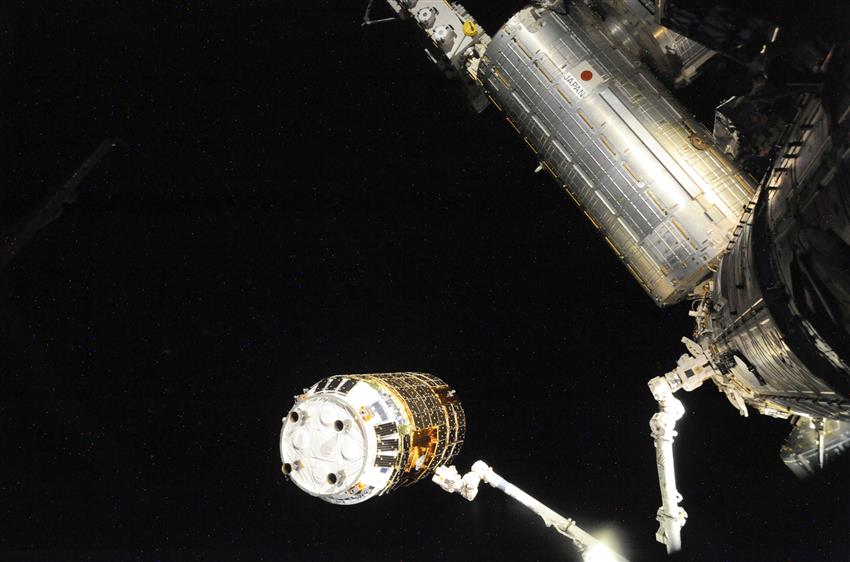 On aperçoit le Canadarm2 en pleine opération alors qu'il effectue la toute première saisie d'un engin spatial en vol libre