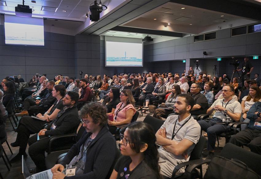 A crowd is sitting in a conference room. 