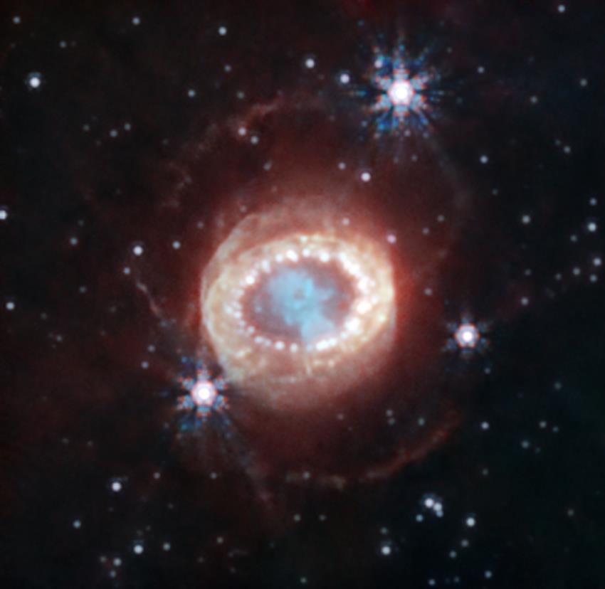 Matière supernova en forme d’un trou de serrure, un anneau brillant autour et de deux autres anneaux peu lumineux.