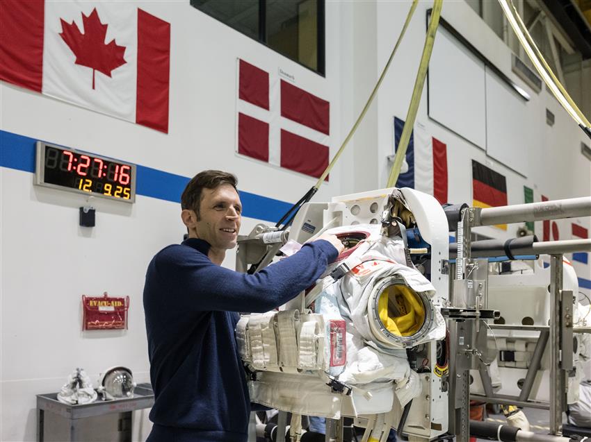 Joshua à côté d'une combinaison spatiale. 