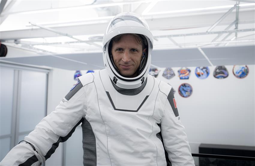 Gros plan de Joshua vêtu d'une combinaison spatiale de SpaceX, avec le casque, visière levée.
