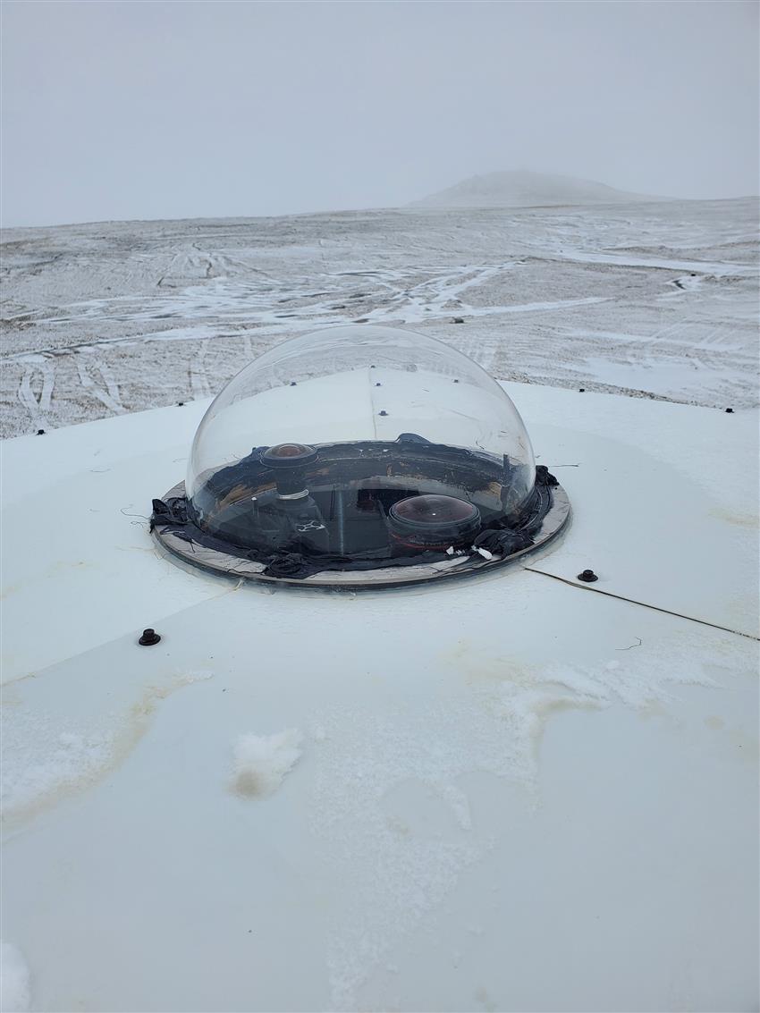 Un dôme transparent protégeant une caméra plein ciel dans un paysage enneigé au Nunavut.