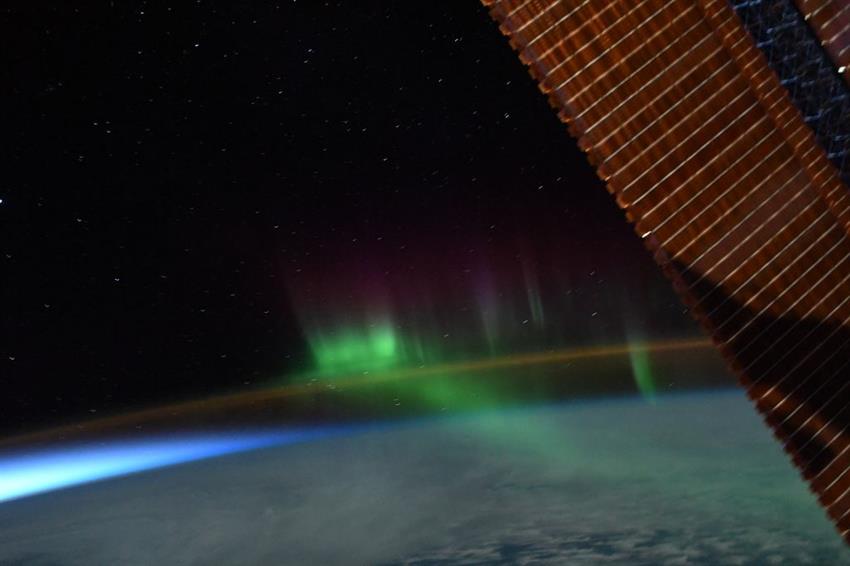 An impressive dance of auroras around the orange airglow of Earth's upper atmosphere as seen from the ISS