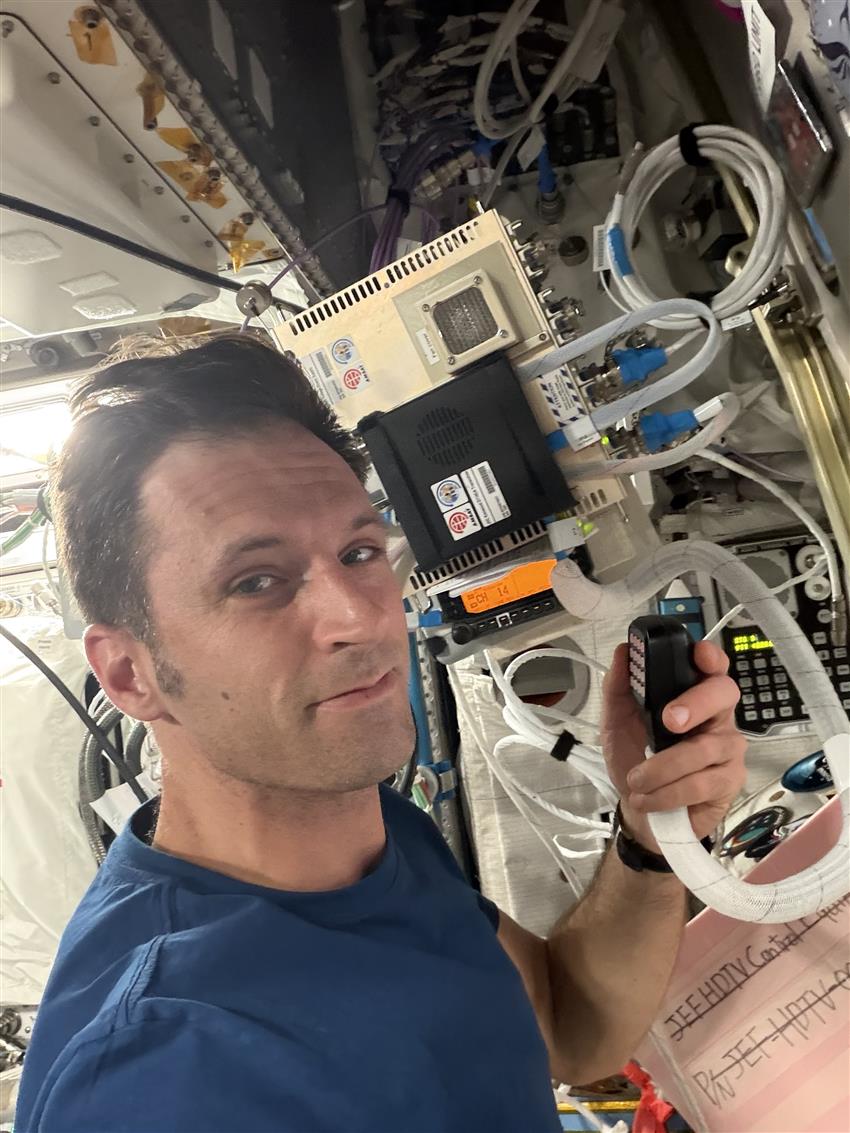 Joshua holds a microphone connected to an amateur radio.