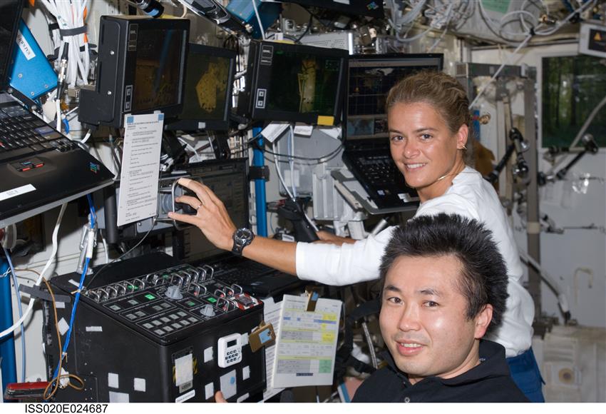Astronauts Koichi Wakata and Julie Payette are at the controls of the Canadarm2 in the Destiny laboratory of the ISS