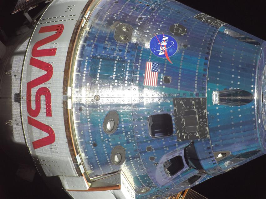 Close-up of the Orion spacecraft, with the NASA logo and the American flag.