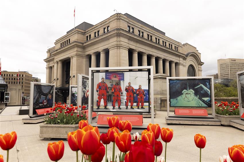 Informational panels and images of astronauts and space technology, installed in an urban square.