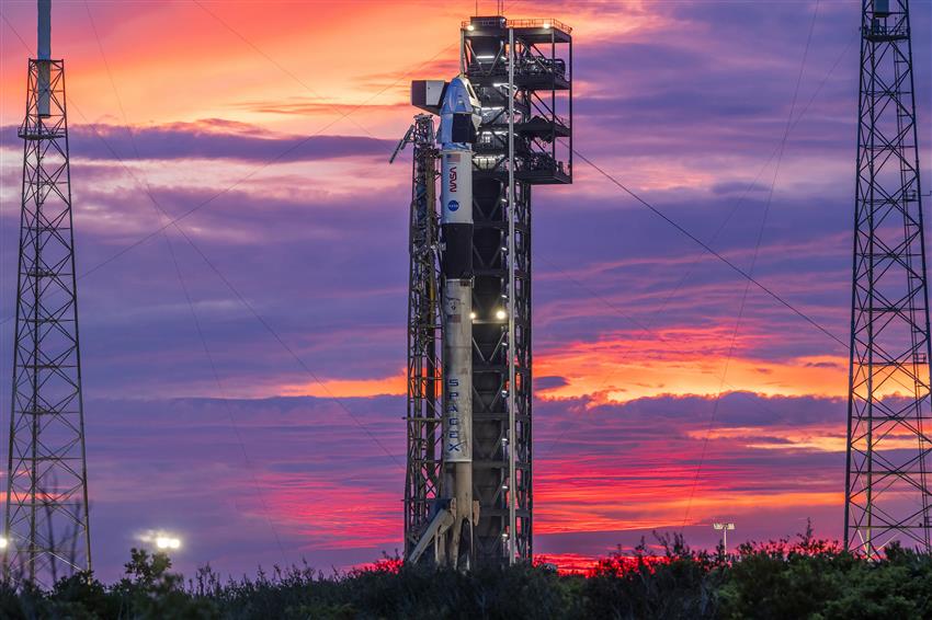 A rocket on the launch pad with a sunset in the background. 