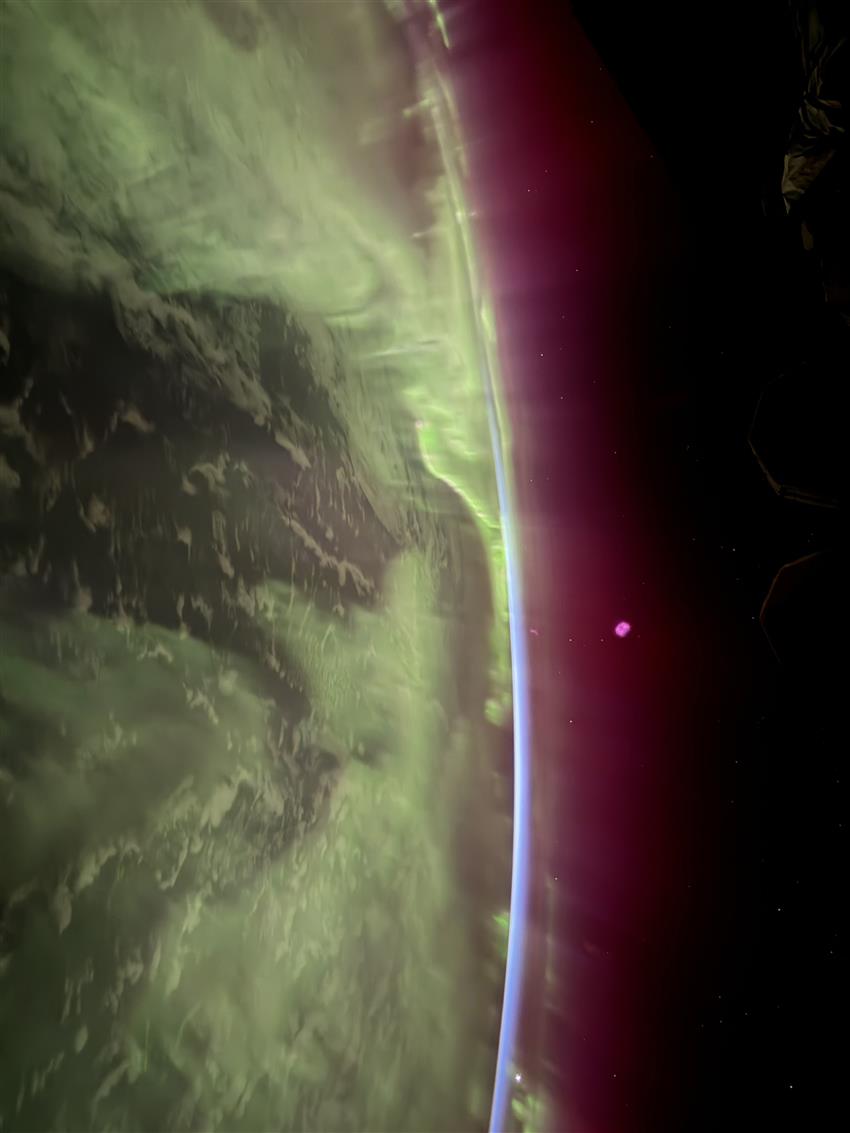 Aurores boréales au-dessus de la surface terrestre vues depuis l'espace.
