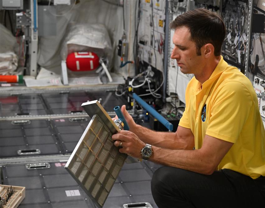 Joshua looks at a piece of equipment he is holding. 