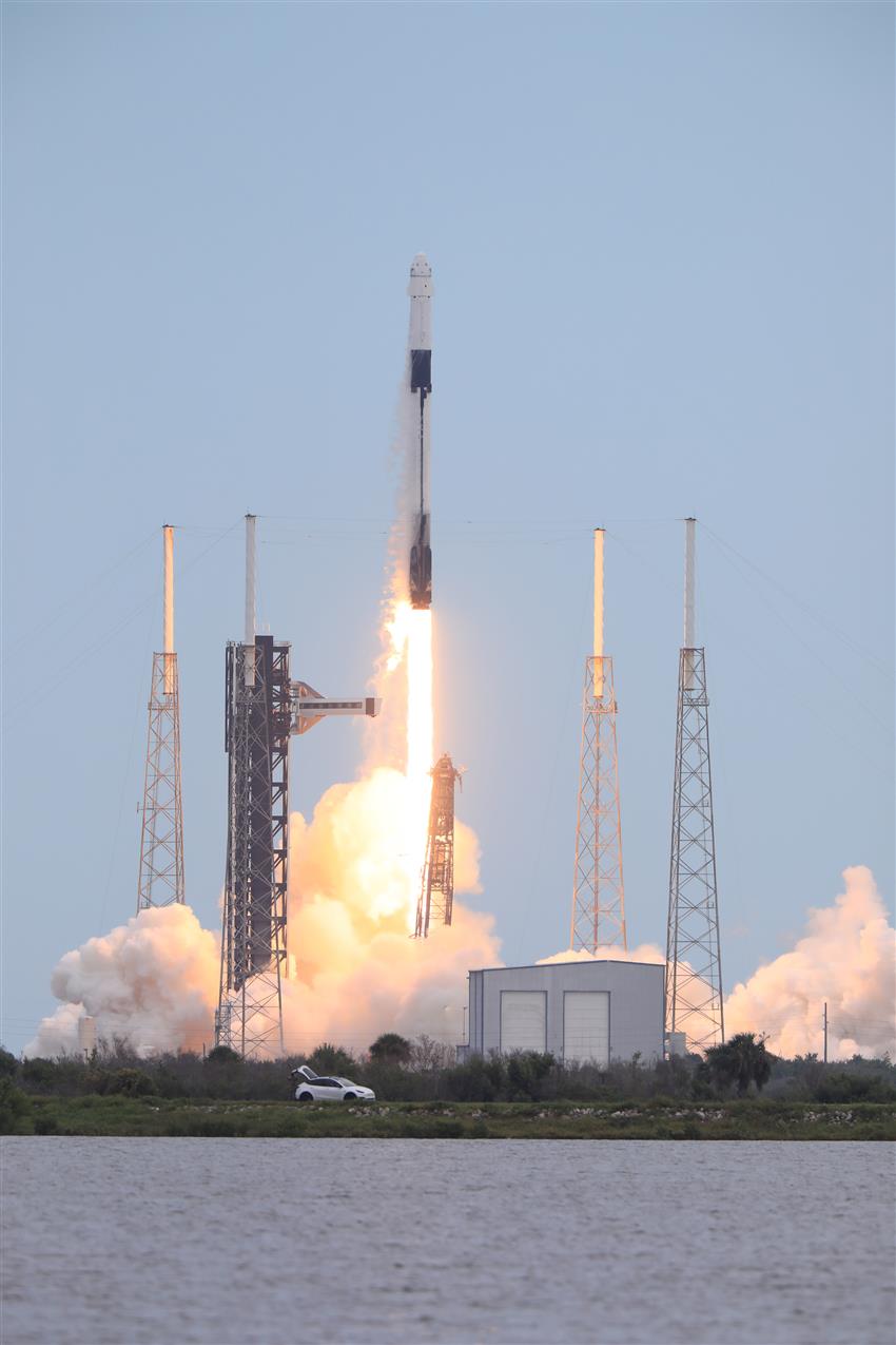 The Falcon rocket and the Dragon spacecraft on the launch pad at liftoff.
