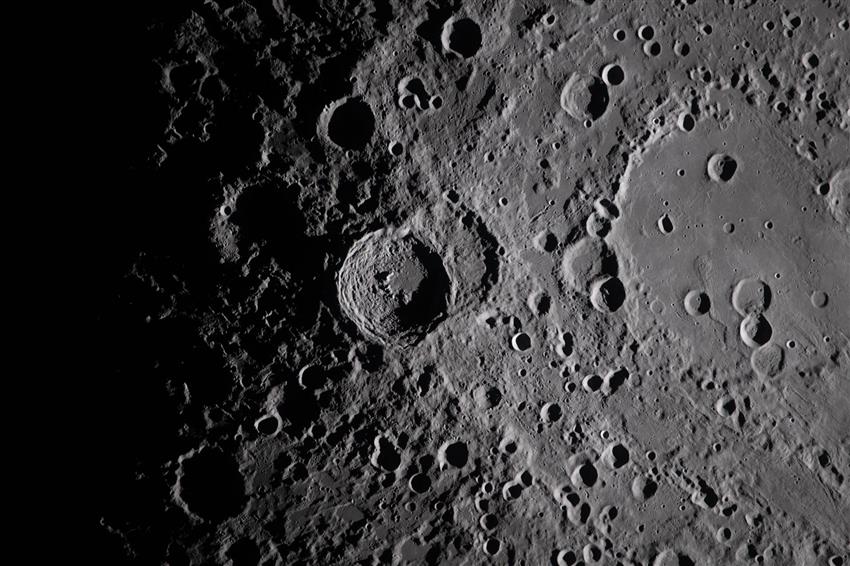 A close-up of the surface of the Moon with lots of visible craters. 