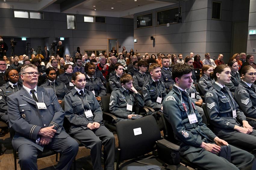 About fifteen cadets are seated in a conference centre. They are wearing their uniforms.