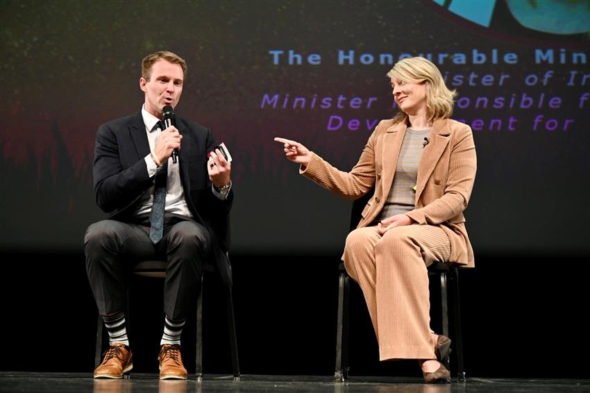 The Honourable Mélanie Joly and Brian Gallant are seated onstage. 