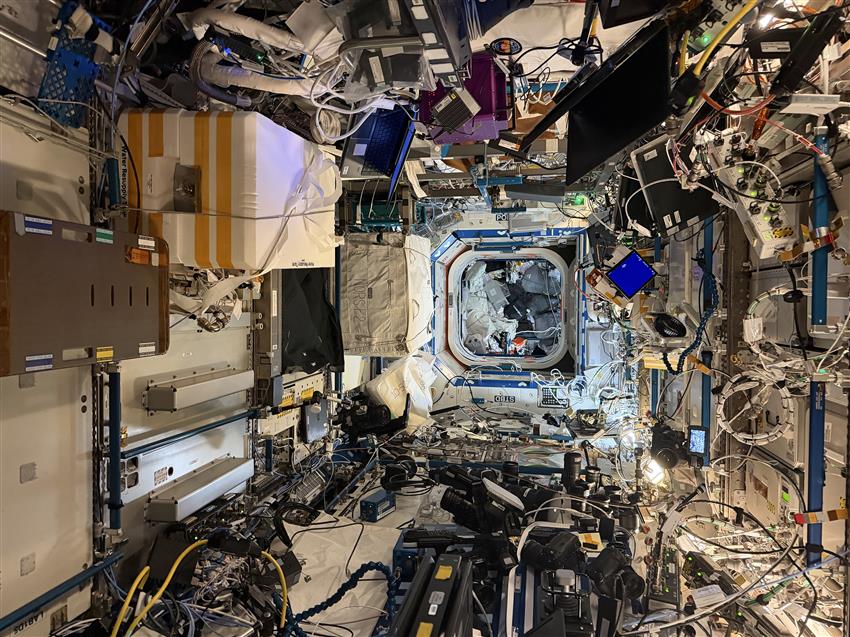 Vue de l'intérieur de la Station montrant des modules remplis d'équipements, de câbles et de postes de travail.