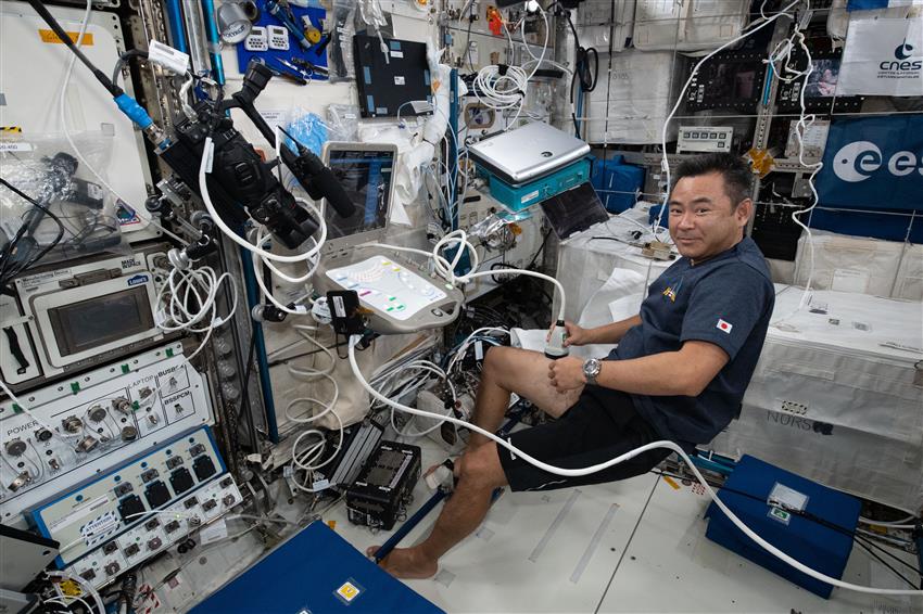 Astronaut Akihiko Hoshide of the JAXA scans the femoral artery in his right leg with an ultrasound device on the ISS