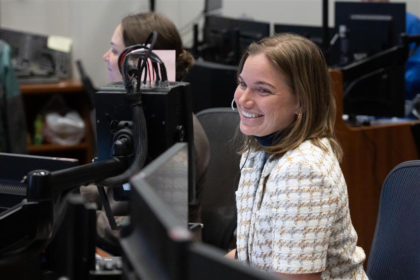 Jenni est assise devant des écrans d'ordinateur.