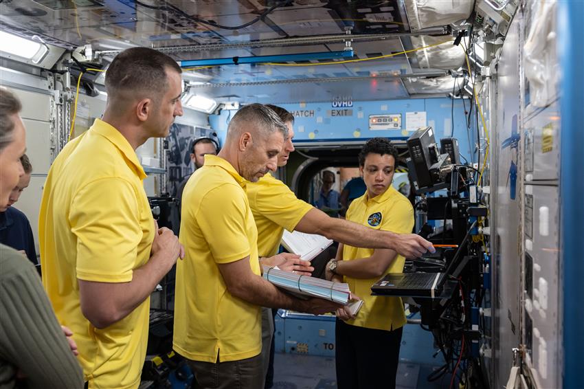 Sergueï, Luke, Joshua et Jessica dans une maquette de la Station spatiale internationale.