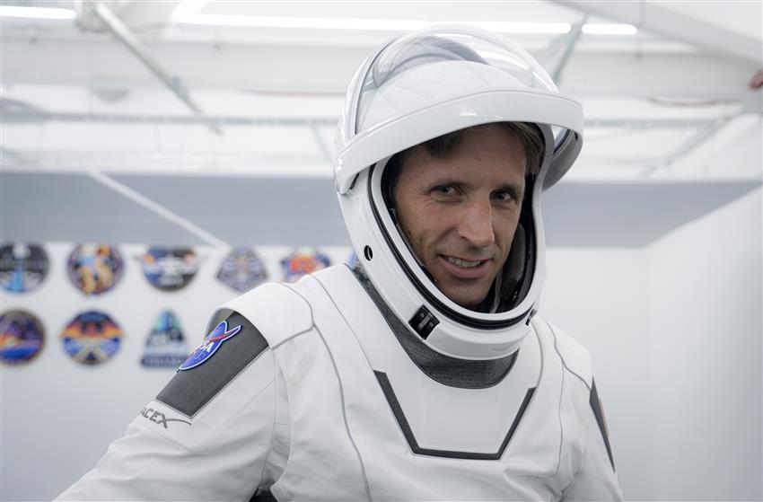 Gros plan de Joshua vêtu d'une combinaison spatiale de SpaceX, avec le casque, visière levée.