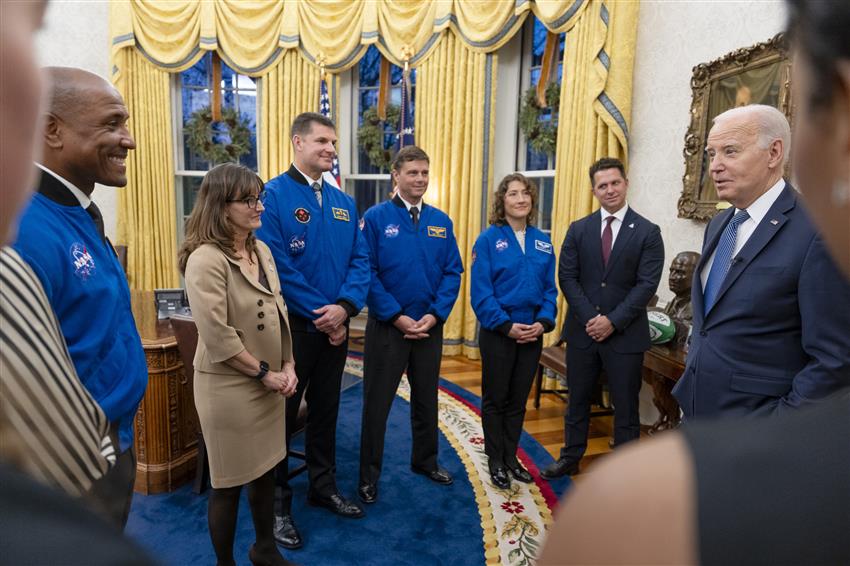 The astronauts stand with their family members and talk to Joe Biden in the Oval Office.