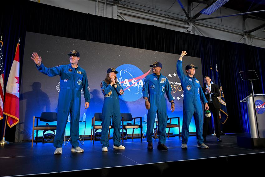 Jeremy, Christina, Victor, and Reid and Jared stand on a stage. 