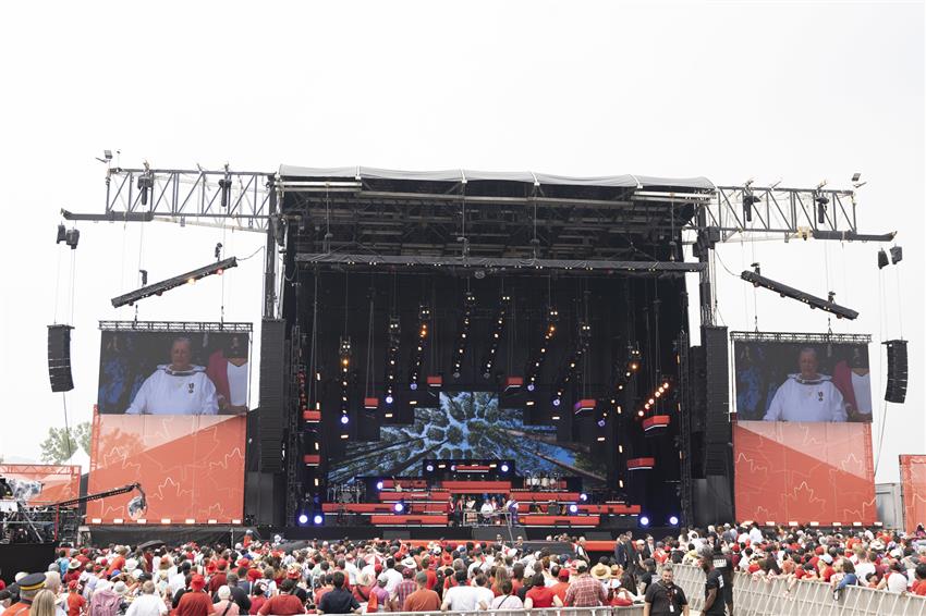 Canada Day 2023 stage in Ottawa with large screens on each side, with a large crowd in front