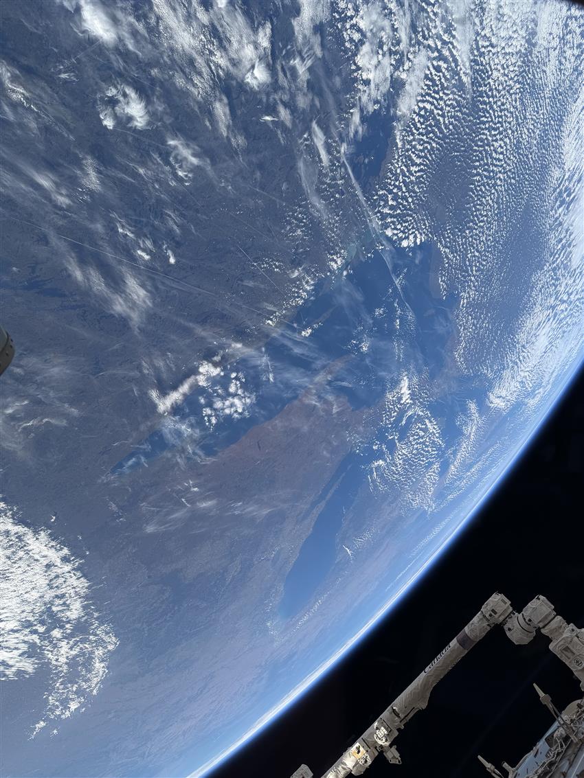 View of the Great Lakes with the Canadarm2 robotic arm visible in the foreground.