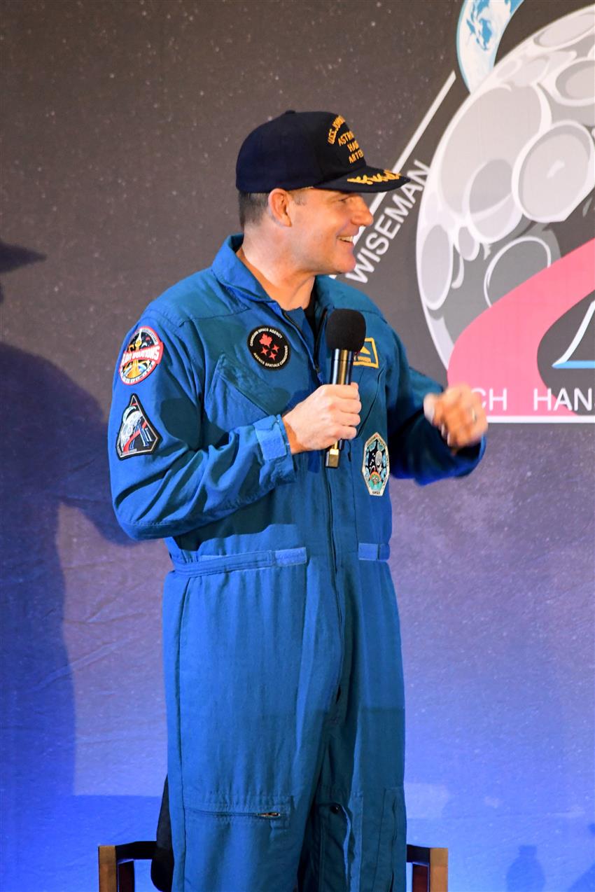 Jeremy holds a microphone on stage. 