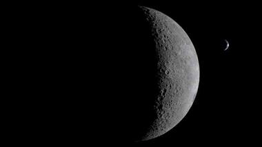 Lune partiellement éclairée dans l'espace, avec la planète Terre visible à l'arrière-plan.